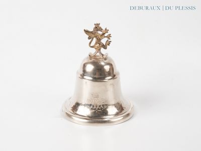 a silver bell with an angel on top of it