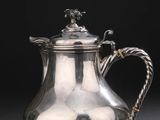 une cafetière en argent avec une poignée en corde sur fond noir
