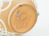 a close up of a vase on a white surface