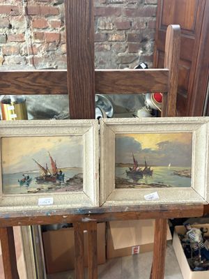 two paintings of boats on a table in front of a brick wall