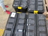 many black boxes sitting on the ground next to a pallet