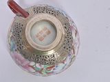 a small vase with a handle on a white surface