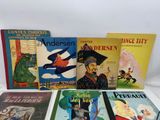 several children ' s books are lined up on a white surface