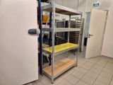 un réfrigérateur et des étagères dans une pièce au sol carrelé