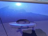 a shadow of a cat on the door handle of a blue car