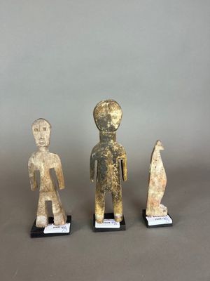 trois figurines représentant un homme et une femme, posées sur des socles