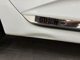 a close up of a white car with a sticker on it