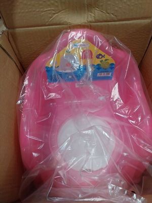 emballage d'un WC rose dans une boîte en carton recouverte d'un film plastique