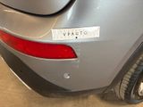 the rear end of a silver car with a sticker on it ' s bumper