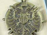 a silver medal with a gold eagle on it in a box