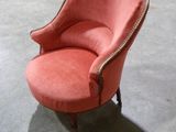 une chaise rose qui se trouve dans une pièce