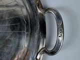 a silver tray with a handle on a white table