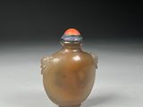 a small glass bottle with an orange cap on it