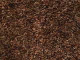 tapis à poils longs marron sur lequel est déposé un tas de feuilles