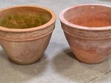 deux pots en terre cuite posés l'un à côté de l'autre sur le sol