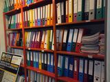 de nombreux dossiers sur les étagères de ce bureau