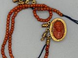 un gros plan d'un collier de perles orné d'un médaillon