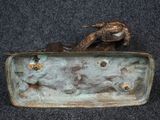 a bronze statue of a dog and a cat in a box