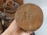 a person holding a wooden object with a cross on it