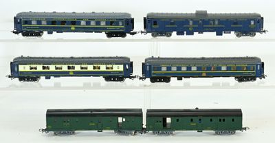 quatre wagons différents exposés sur une surface blanche