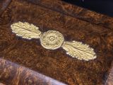 a wooden box with a gold decoration on it