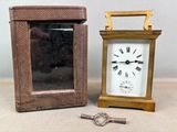 une petite horloge posée à côté d'une petite boîte