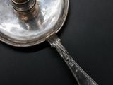 a silver plate with a spoon on it on a black surface