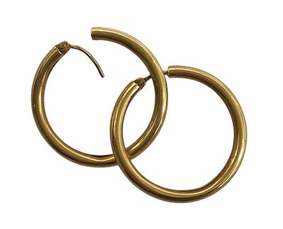 une paire de boucles d'oreilles en or sur fond blanc
