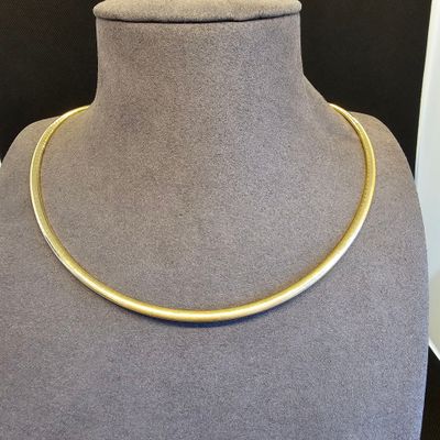 un gros plan d'un collier en or autour du cou d'un mannequin