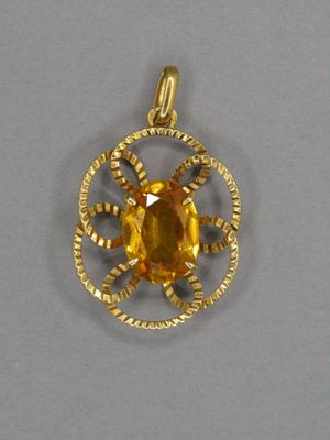 un gros plan d'un pendentif en or serti d'une citrine