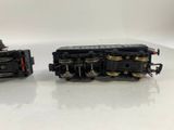 two toy trains sitting side by side on a white surface
