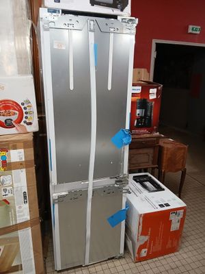 a refrigerator and a refrigerator freezer in the middle of a room