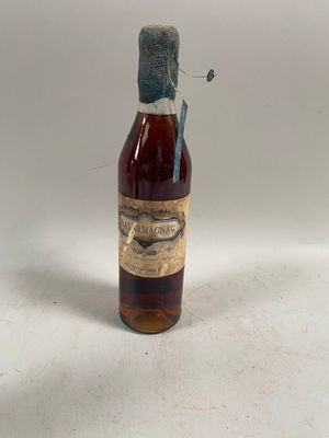 une vieille bouteille de whisky posée sur une table blanche
