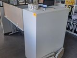 un bureau sur lequel est posée une plante, au milieu d'une pièce