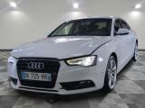L'Audi blanche est garée dans une grande pièce au sol carrelé.
