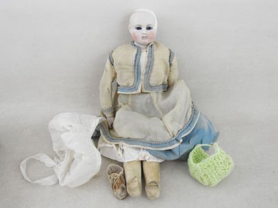 une poupée assise par terre à côté d'un panier
