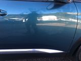 the reflection of a man in a car is seen on the side of the car