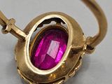 a close up of a gold ring with a pink stone