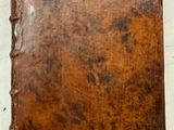 un vieux livre à la couverture en cuir marron posé sur une table