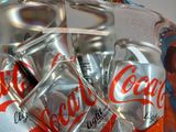 bottles of coca cola in a glass container on a table