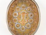 a gold plate with a design on it on a white surface