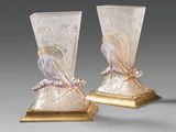 pair of glass vases with a gold base and a bird decoration