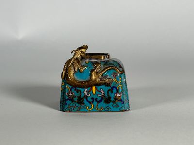 une petite clochette bleue et dorée ornée d'un dragon