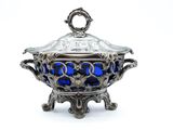 a silver and blue bowl with a lid on a stand