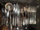 a lot of silver spoons and spoon spoons hanging from a rack