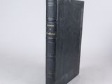 a black book with gold lettering on it sitting on a white surface