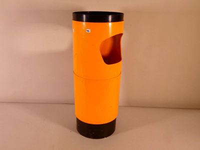 une poubelle orange avec un couvercle noir posée sur une table