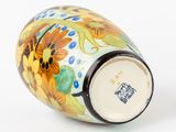 a vase with a floral design on it on a white surface