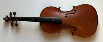 Un vieux violon est accroché au mur.