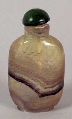 a small glass bottle with a green lid on a table